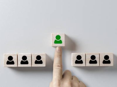 Human resources management and recruitment business hiring concept, corporate hierarchy, recruiter complete team by one leader person. hand selects cube with desired person highlighted in green.